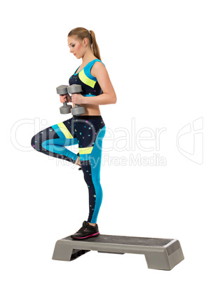 Sporty woman keeps balance standing on one leg