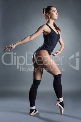 Beautiful ballerina warms up in studio