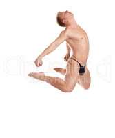 Muscular half-naked man jumping, isolated on white