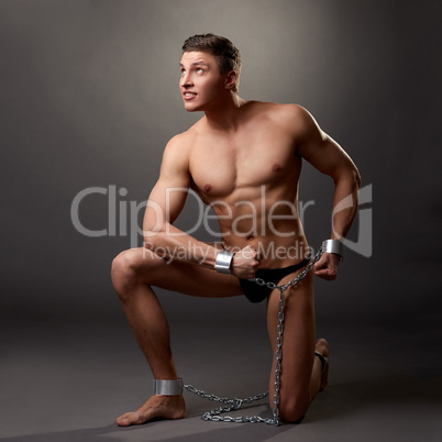 Sexy bodybuilder posing in handcuffs