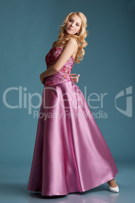Beautiful young girl posing in long pink dress