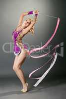 Studio shot of curved gymnast dancing with ribbon