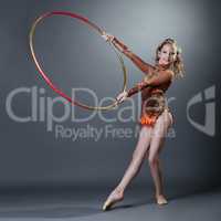 Adorable young gymnast performing with hoop