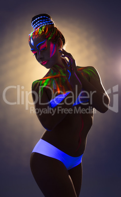 Seductive model posing with body art in UV light