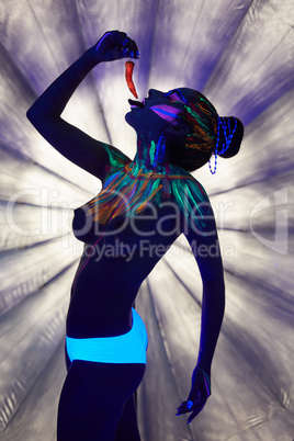 Topless girl posing with chili under UV light
