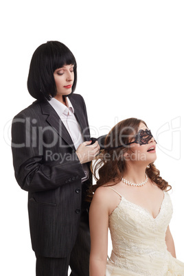 Gay marriage. Groom tied mask over bride's eyes