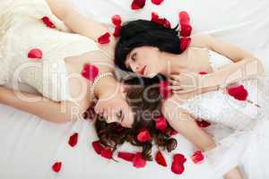 Lovely women posing in wedding dresses with petals