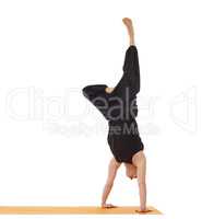 Flexible yoga man doing handstand in studio