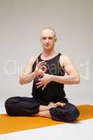 Handsome yogi posing at camera while meditating