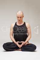 Calm middle-aged man exercising yoga in studio