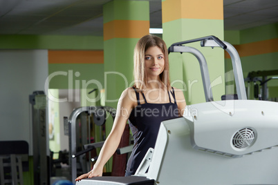 Image of pretty blue-eyed girl trains in gym