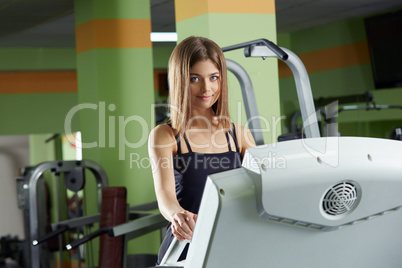 Lovely girl posing at camera while training in gym