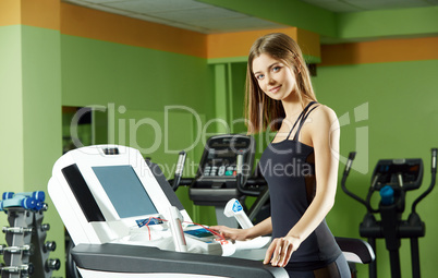 Cute girl exercising on simulator in gym
