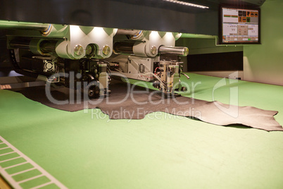 Image of robotic machine cutting leather for parts