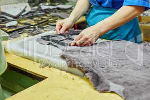 Production of fur insoles. Worker uses template