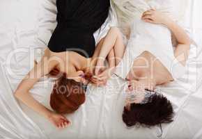 Top view of blindfolded pretty women lying in bed