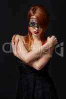 Red-haired beauty with lace mask on eyes