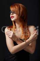 Portrait of red-haired submissive in handcuffs