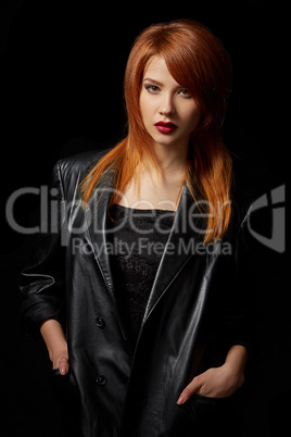 Sexy red-haired model posing in leather jacket