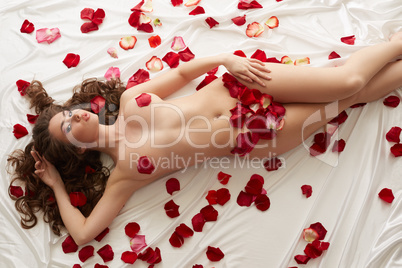 Image of nude beautiful woman with rose petals