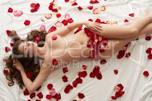 Image of nude beautiful woman with rose petals