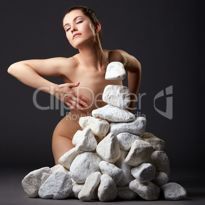 Telekinesis. Inspired nude woman with stones
