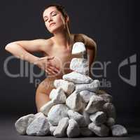 Telekinesis. Inspired nude woman with stones