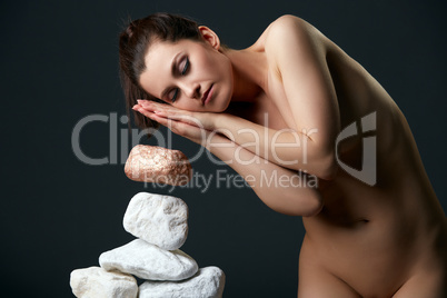 Woman with closed eyes moving stones by thought
