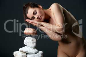 Woman with closed eyes moving stones by thought