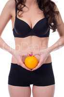 Concept of cellulite. Slim girl holding orange.