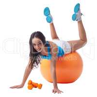 Sexy woman posing while exercising on fitness ball
