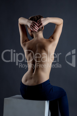 Rear view of seminude model posing in studio