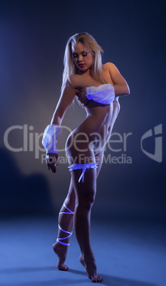 Shy naked dancer posing in ultraviolet light
