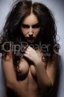 Portrait of confident brunette posing topless