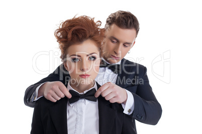 Gallant man straightens tie to his sexy girlfriend
