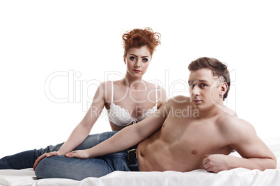 Attractive young heterosexual pair posing in bed