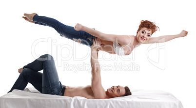 Funny young people perform acrobatic stunt in bed