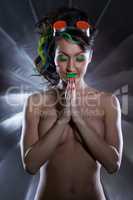 UV make-up. Sexy naked woman in prayer pose