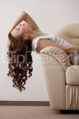 Image of dreaming model reclining on leather sofa