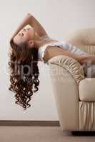 Image of dreaming model reclining on leather sofa