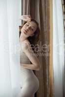 Dreamy model in negligee, on curtain background