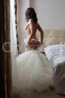 Bride takes off her wedding dress in hotel room