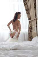 Rear view of sexy bride takes off wedding dress