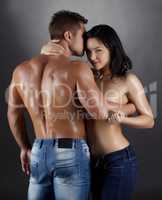 Flirtatious woman and strong man posing in studio