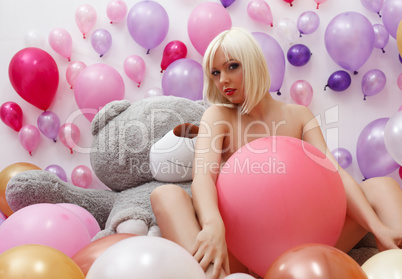 Sexy blonde posing nude in studio with balloons