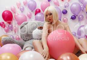 Sexy blonde posing nude in studio with balloons