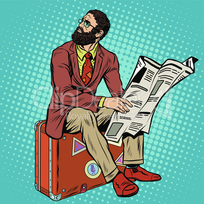 Bearded hipster traveler reading a newspaper