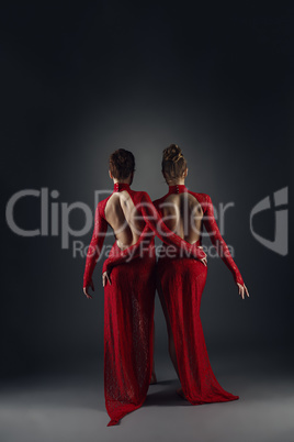 Rear view on elegant dancers in long lace dresses