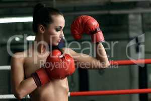 Pretty naked female boxer looks at her biceps