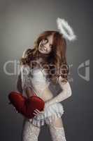 Smiling red-haired beauty posing in angel costume